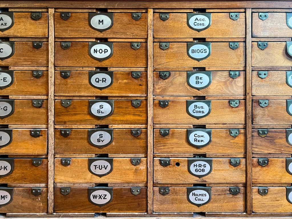 A wooden case with different letters on each drawer