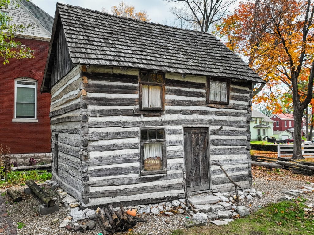 The two-story log cabin behind the John Wood Mansion