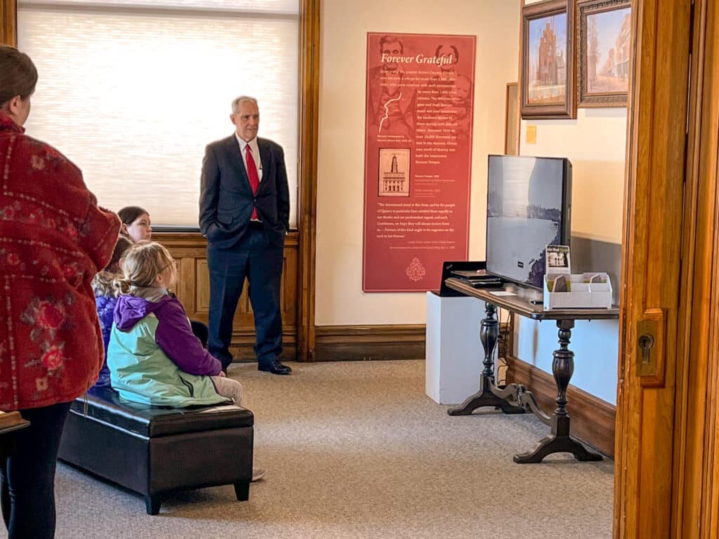 A man presenting a video on a school tour