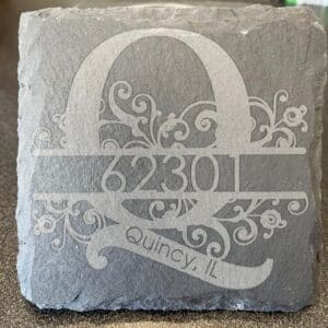slate coasters with "Q" and "62301" sketched into them. Ornate.